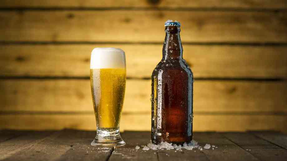 A glass and a bottle of beer