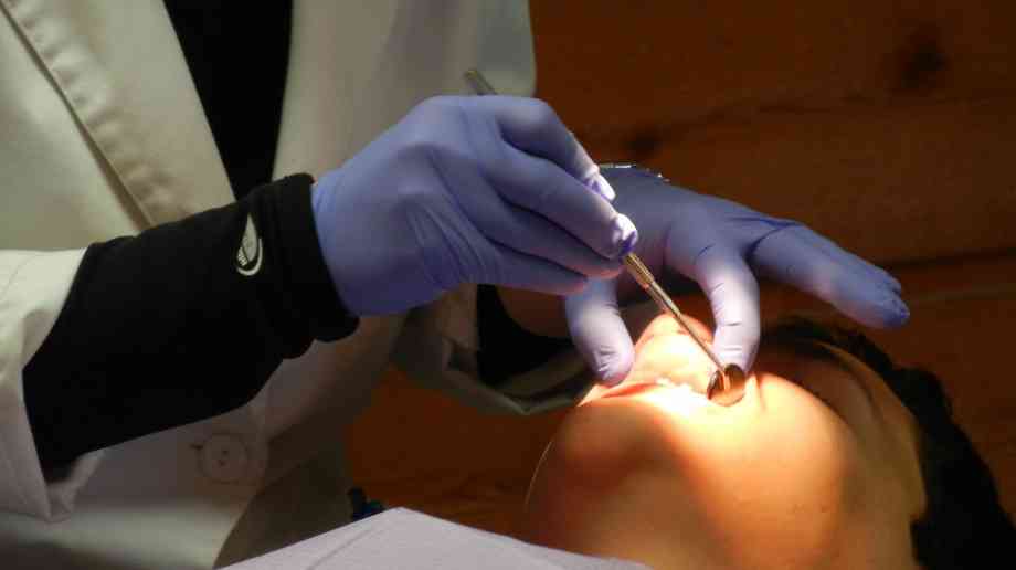 a dentist checking someone's teeth